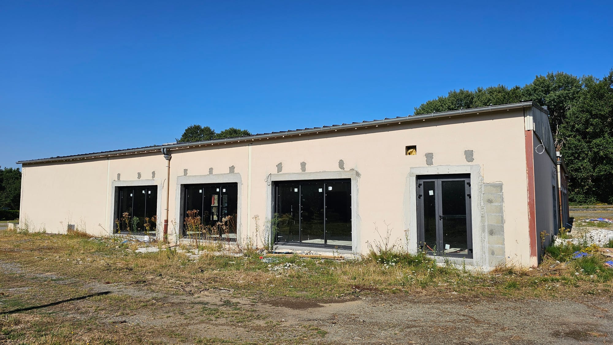 Les nouvelles baies vitrées à menuiserie noire posées sur la façade ravalée